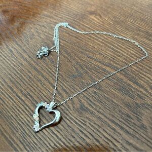 Silver tilted heart necklace with pale pink, purple, yellow, and blue stones